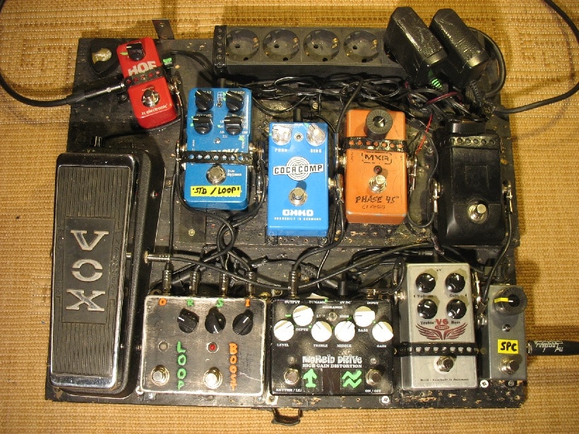 •Der Signalverlauf ist etwas verquert. Reihenfolge: rechts unten EMG SPC Booster --> Korg Pitchblack --> MXR Phase 45 --> verbasteltes Vox Wah --> V6 Vox-artiger Selbstbau-Zerrer --> Weehbo Morbid Drive --> Okko Coca Comp ---> Turbo Ratte (als Soloboost) + Bypass Loop --> Hall Of Fame Mini --> zum Amp.