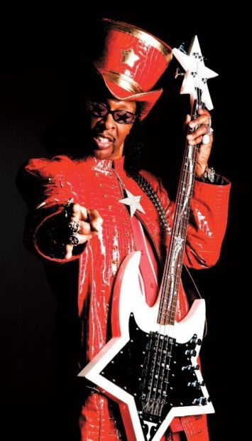 Bootsy Collins ist auffällig mit rotem Mantel, Hut und Sonnenbrille gekleidet und hält den sternenförmigen "Star Bass" in der Hand.
